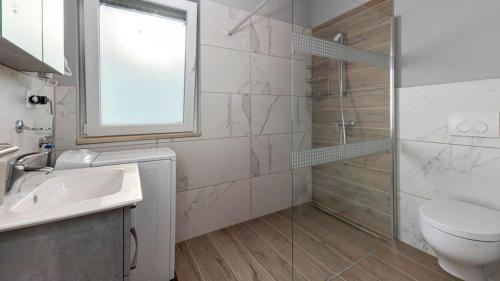 a bathroom with a toilet and a sink and a shower at Beautiful new Apartment Ancora 2 in Nerezine