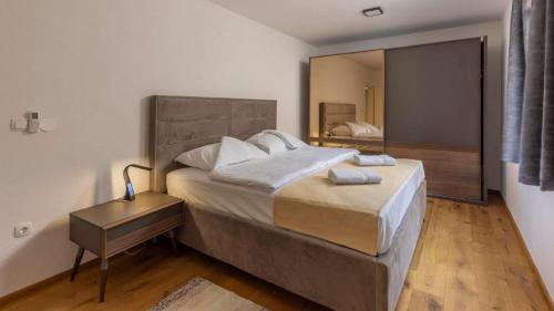 um quarto com uma cama grande e um espelho em Beautiful new Apartment Ancora 2 em Nerezine
