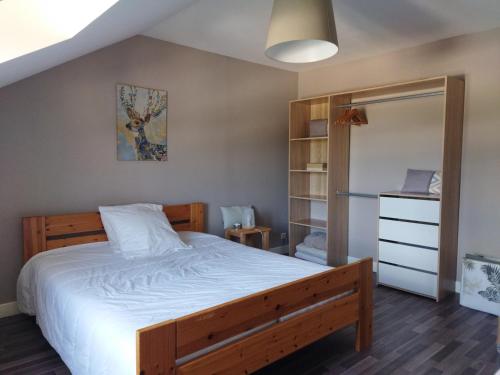 1 dormitorio con 1 cama grande y armario en Les Fortelles, en Châtillon-sur-Broué