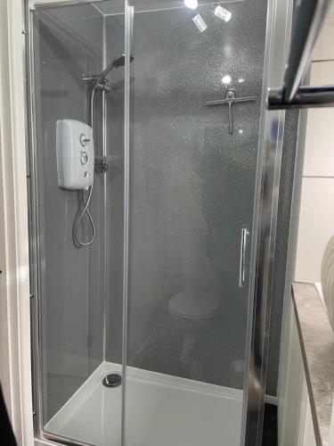 a shower with a glass door in a bathroom at West Moor View Apartment in Launceston