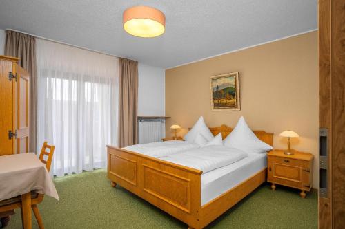 a bedroom with a large bed with white pillows at Ferienwohnungen Jonuscheit in Bodenmais