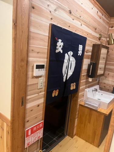 a bathroom with a sink and a flag at 離れの宿　かぶろの庭 in Matsukawa