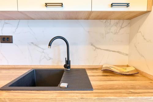 a kitchen sink with a faucet on a counter at MDApartment in Infinity Beach Resort- Parking in Mamaia