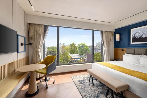 Postel nebo postele na pokoji v ubytování Ramada Encore by Wyndham Siliguri Sevoke Road