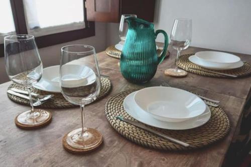 una mesa de madera con platos y copas de vino. en Pintularrama - Casa Rural en Póo de Llanes en poo de Llanes