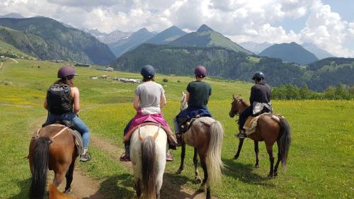 a group of people riding horses in a field at lileo in Omalo