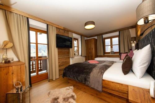 ein Schlafzimmer mit einem großen Bett in einem Zimmer mit Fenstern in der Unterkunft Appartements Lehenhof in St. Johann im Pongau