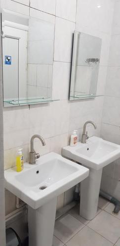 a white bathroom with two sinks and a mirror at ASA Hotel in Yerevan