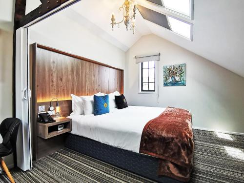 a bedroom with a large bed with a wooden headboard at The Salisbury Business Class in Christchurch