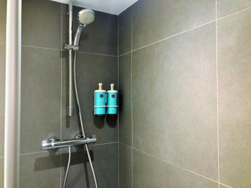 a bathroom with a shower with two bottles on the wall at Novotel Suites Montpellier Antigone in Montpellier