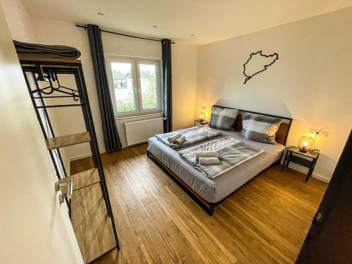 1 dormitorio con 1 cama con mapa en la pared en Südschleife Appartements - App. 2 - WLAN - Direkt am Ring, en Reimerath