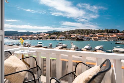 balcón con sillas y vistas al puerto deportivo en Holiday Home Shabby en Vela Luka