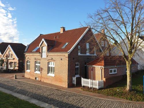 une grande maison en briques sur le côté d'une rue dans l'établissement Ferienwohnungen Meerhuus_ 45229, à Ditzum