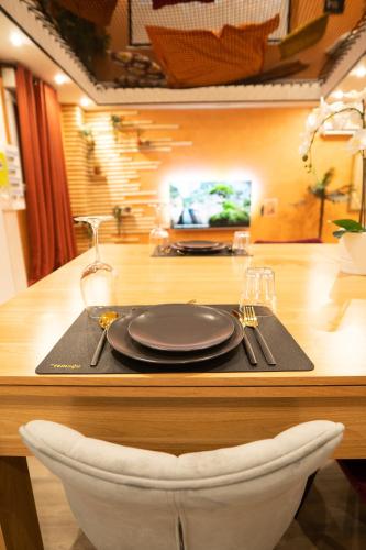 a table with a black plate and a white chair at Capsule Marrakech I Chicha I Sauna I Balnéo I Console PS5 I Cinéma in Trith-Saint-Léger