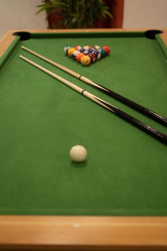 a green felt pool table with a cue ball and chopsticks at Capsule Marrakech I Chicha I Sauna I Balnéo I Console PS5 I Cinéma in Trith-Saint-Léger
