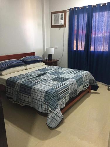 a bedroom with a bed and a blue curtain at Donadel Hometel in Iloilo City