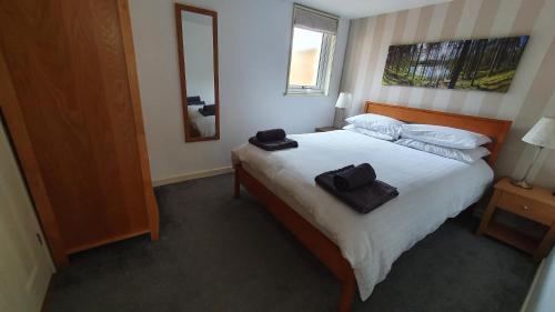 um quarto com uma cama com duas toalhas pretas em Herons Rest em Drumnadrochit