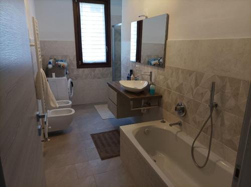 ein Badezimmer mit einer Badewanne, einem Waschbecken und einem WC in der Unterkunft Appartamento suite vicino Milano & Monza in Concorezzo