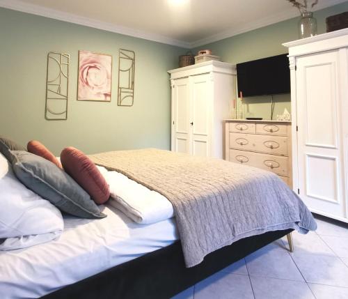 a bedroom with a bed with pillows and a dresser at Homelig Altstadt Ferienwohnung Sassnitz 3 in Sassnitz