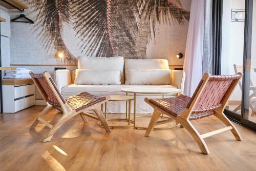 ein Wohnzimmer mit einem Sofa, 2 Stühlen und einem Tisch in der Unterkunft Casa Indiana Hotel Boutique in Blanes