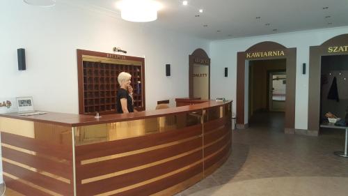 a woman standing at a counter in a hair salon at Leśna Radość in Jastrząb