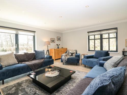 a living room with a blue couch and chairs at Woodend Croft in Ellon