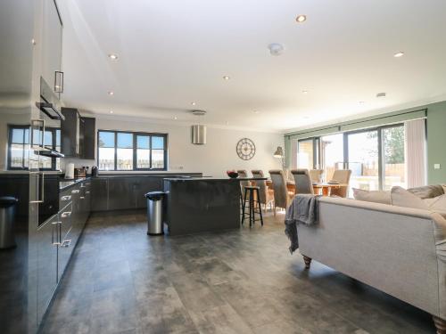 a kitchen and living room with a couch and a table at Woodend Croft in Ellon