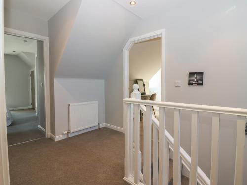 a staircase in a home with white walls at Woodend Croft in Ellon