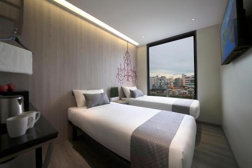 a hotel room with two beds and a large window at Hotel 81 Premier Princess in Singapore