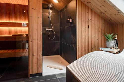 een badkamer met een douche en een bed in een kamer bij Osprey Lodge in Aviemore