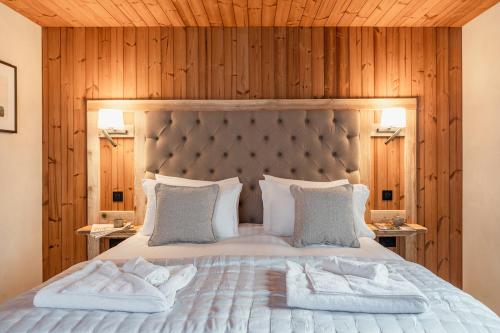 een slaapkamer met een groot bed en houten wanden bij Osprey Lodge in Aviemore