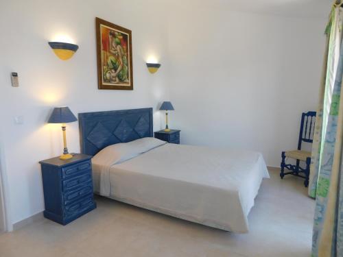 - une chambre avec un lit, deux lampes et une chaise dans l'établissement Estrela Mar Marina Villa, à Quarteira