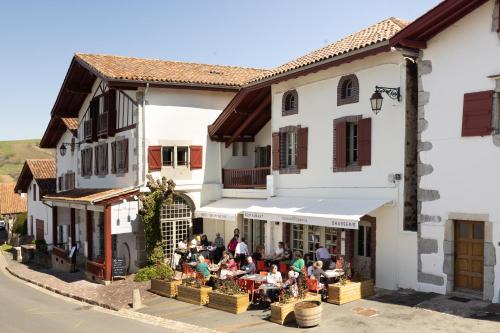 a group of people sitting at tables outside of a building at Hotel La Maison Oppoca in Ainhoa