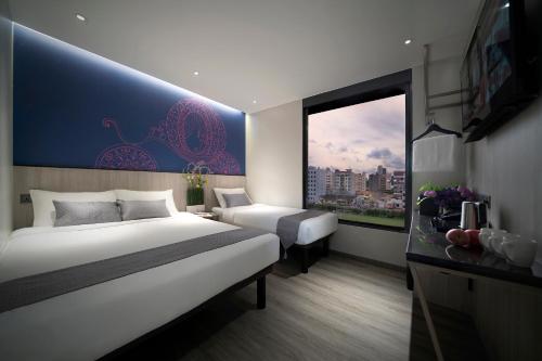 a hotel room with two beds and a window at Hotel 81 Premier Princess in Singapore