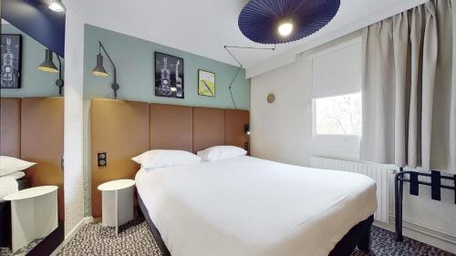 パリにあるイビス パリ ブランシオン パルク デ ゼクスポジション 15区のベッドルーム(大きな白いベッド1台、窓付)