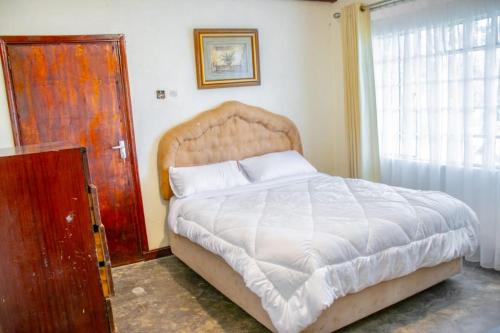 a bedroom with a large bed and a window at Stone Camp Naivasha in Naivasha
