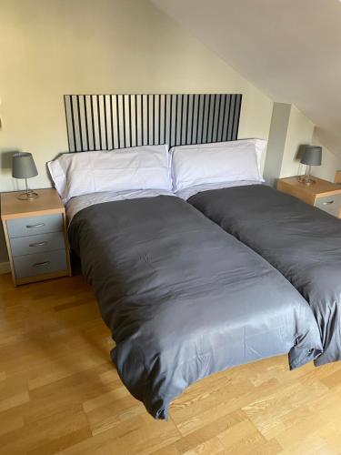 a large bed in a bedroom with two night stands at VUT Dúplex Miraluz in Cuenca