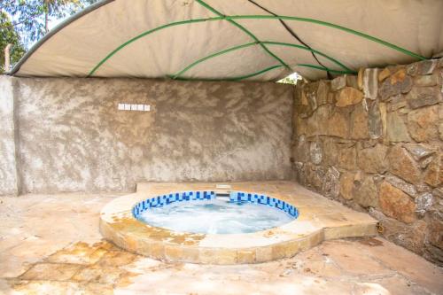 a hot tub in a building with a stone wall at Stone Camp Naivasha in Naivasha