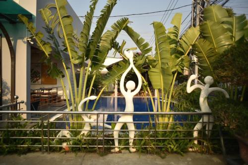 two statues of swans on a fence in front of plants at Window Homestay in Kon Tum