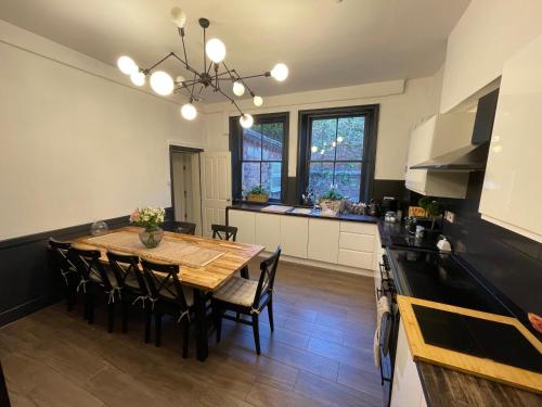 a kitchen and dining room with a table and chairs at Deluxe Huge Detached House with Parking, sleeps up to 30 people, 2m from Liverpool City Centre in Liverpool