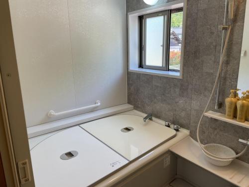 Ein Badezimmer in der Unterkunft 30畳の大広間12名宿泊可能な水月湖畔宿大五郎丸ー水月湖クルージング隣接