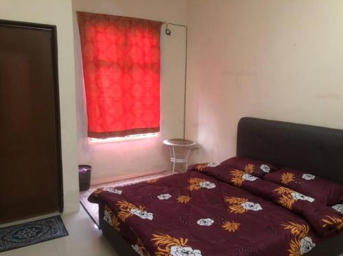 Salak Indah Homestay KLIA/KLIA2 في سيبانغ: غرفة نوم بسرير ونافذة حمراء