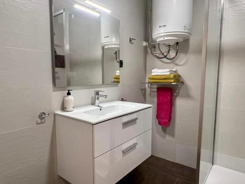 a white bathroom with a sink and a mirror at Bcn Friendly Parlament in Barcelona