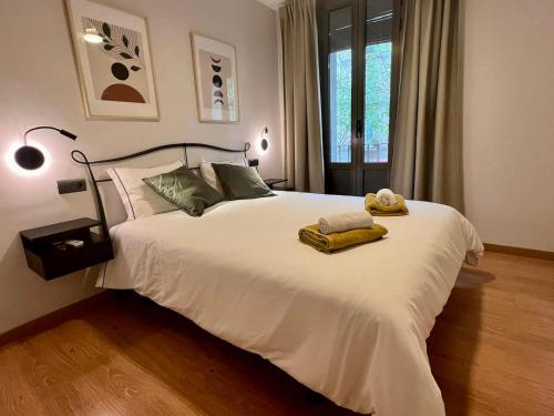 a bedroom with a white bed with two towels on it at Bcn Friendly Parlament in Barcelona