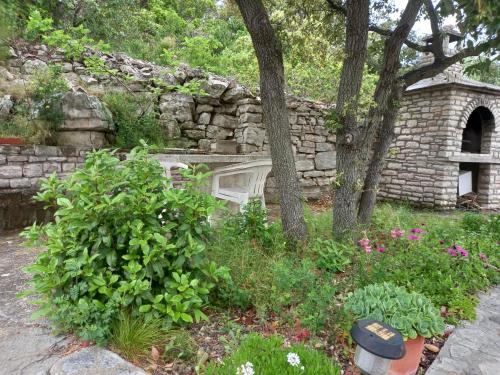 an old stone wall with some plants and trees at Biancaneve in Stomorska
