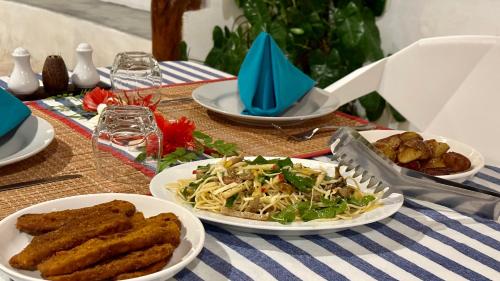 a table with plates of food on top of it at Masfalhi View Inn in Felidhoo