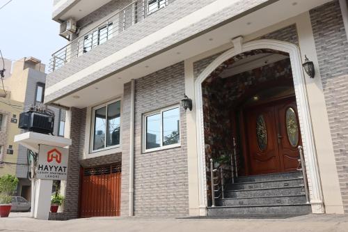 a brick building with a red door and a entrance at Hayyat Luxury Hotel Suites in Lahore