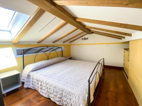 ein Schlafzimmer mit einem Bett in einem Zimmer mit Holzböden in der Unterkunft La Casetta - Appartamento Centro Storico Albenga in Albenga