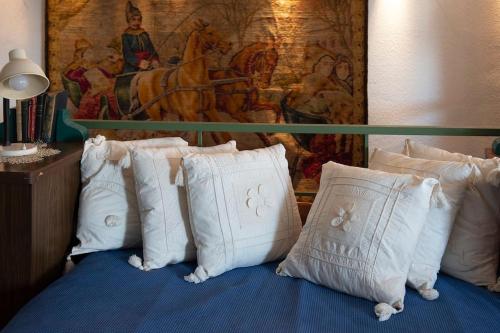 a bed with white pillows and a painting on the wall at Architect Art Studio in Athens