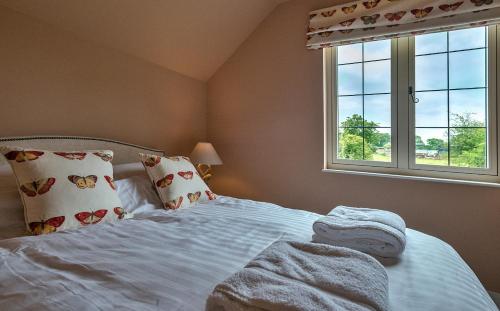 ShrawardineにあるFinest Retreats - Fox and Hareのベッドルーム1室(白いベッド1台、枕付)、窓が備わります。